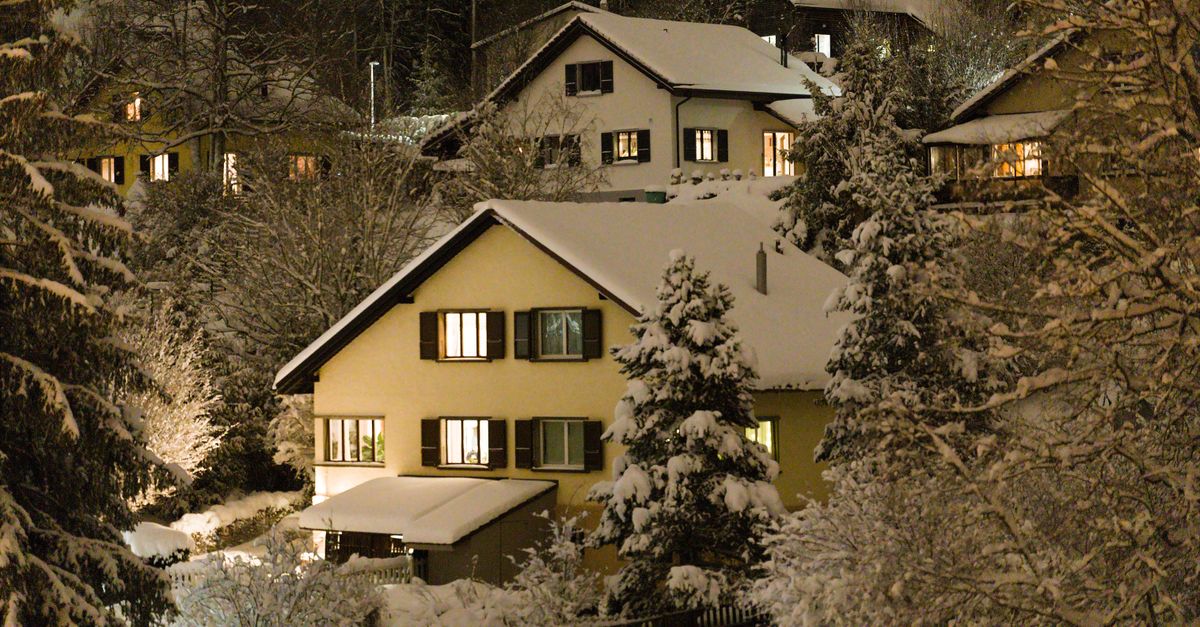 Charming snow-covered houses at night in a serene winter landscape.
